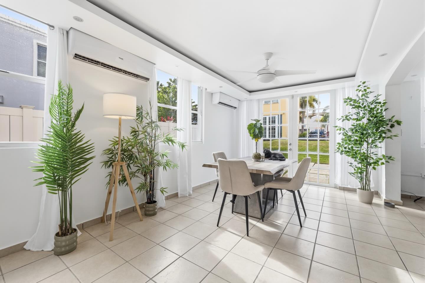 Bright dining room with tropical plants and French doors